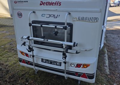 Zadná časť obytného prívesu s nosičom na bicykle.
